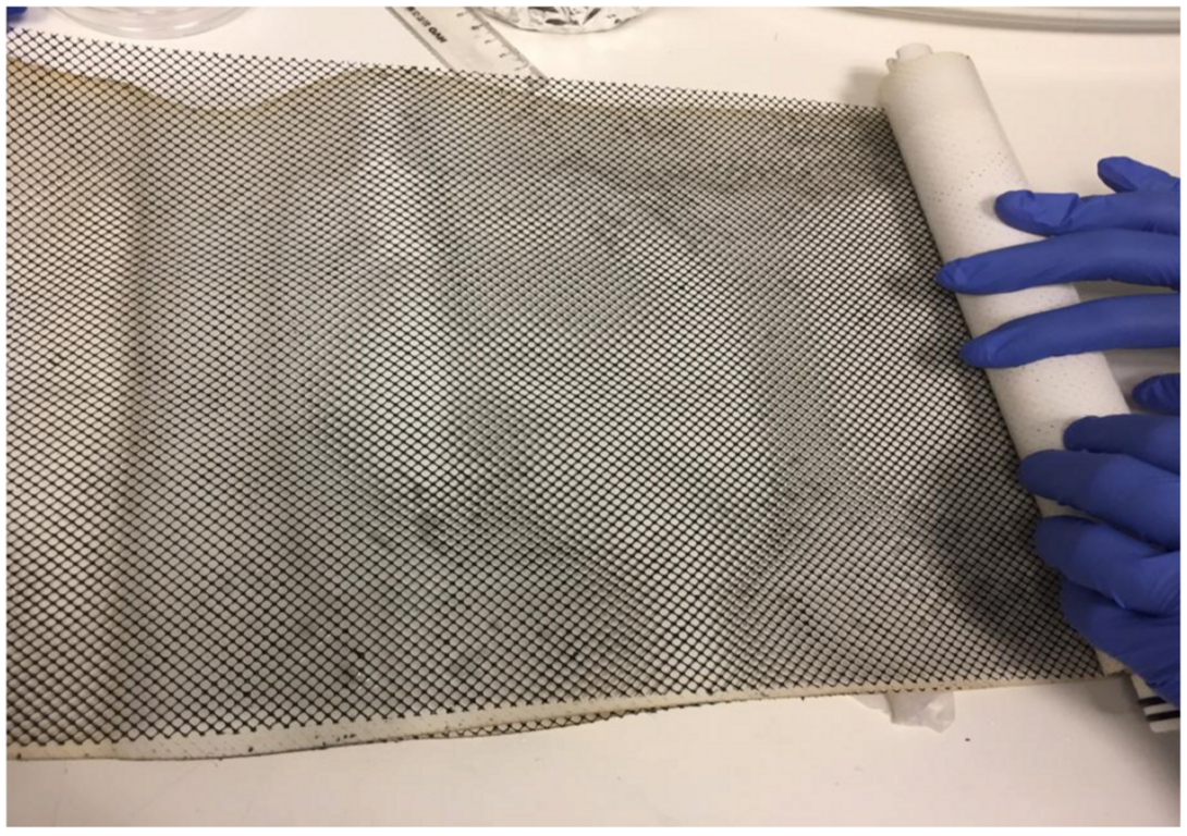Das Netz ist Teil eines Wickelmoduls für Brackwasseraufbereitung. Das Modul ist ca. 30 cm lang und die dunkle Beschichtung des Netzes ist eine elektrisch leitfähige laserinduzierte Graphen Beschichtung. 