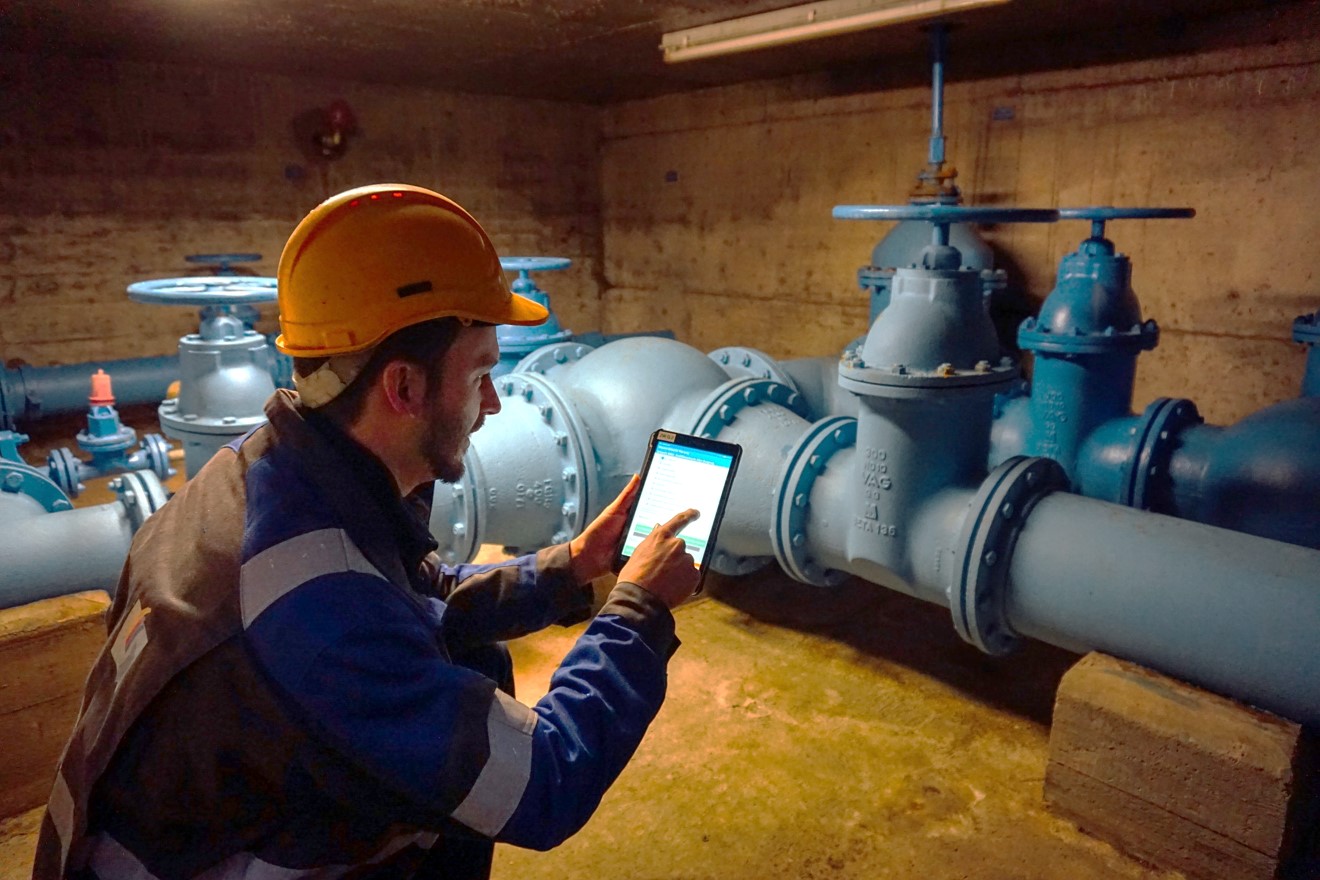 Wassermeister vor Ort mit Tablet in der Hand